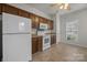 Kitchen featuring a white refrigerator, wood cabinets and eat-in area at 8313 Carob Tree Ln, Charlotte, NC 28215