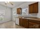 Bright eat-in kitchen area with wood cabinets, a double sink and two windows at 8313 Carob Tree Ln, Charlotte, NC 28215