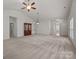 Large living room featuring neutral paint, ceiling fan, and entryways to other parts of the home at 8313 Carob Tree Ln, Charlotte, NC 28215