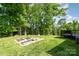 Lush backyard featuring mature trees, a garden area, and a wooden deck, perfect for outdoor enjoyment at 8509 Sienna Dr, Charlotte, NC 28215