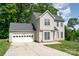 Side view of a charming two-story home featuring a two-car garage, well-kept lawn and driveway at 8509 Sienna Dr, Charlotte, NC 28215