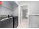 Convenient laundry room featuring modern appliances and storage shelves at 8509 Sienna Dr, Charlotte, NC 28215