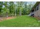 Spacious backyard features lush green grass, mature trees, and brick home with a welcoming staircase at 876 Hardin St # B24, Lancaster, SC 29720