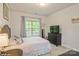 Bedroom features carpet, light pink bedding, light colored curtains, and a TV atop a black dresser at 876 Hardin St # B24, Lancaster, SC 29720