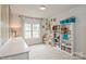 Brightly lit bedroom with white shelves, books, decorations, and a neutral colored carpet at 876 Hardin St # B24, Lancaster, SC 29720