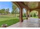 Covered back porch with brick arches offering serene views of the manicured lawn at 89 Wexford Pt, Hickory, NC 28601