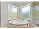 Large soaking tub features frosted windows for privacy and natural light at 89 Wexford Pt, Hickory, NC 28601