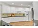 Spacious kitchen features white cabinets, stone backsplash, stainless appliances, and hardwood flooring at 89 Wexford Pt, Hickory, NC 28601