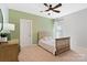 Neutral bedroom with a ceiling fan, one window, and light green accent wall at 962 Herrons Ferry Rd, Rock Hill, SC 29730