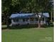 Charming single-story home with a blue metal roof and a well-manicured lawn at , Salisbury, NC 28147