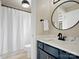 Updated bathroom featuring modern fixtures, navy vanity with marble countertop, and a shower/tub combination at 1030 Westbury Dr, Matthews, NC 28104