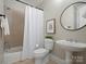 Cozy bathroom with a shower-tub combo, pedestal sink, and neutral tones for a relaxing atmosphere at 1030 Westbury Dr, Matthews, NC 28104