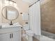 Bathroom with modern fixtures, including a tub with shower and stylish round mirror above the sink at 1030 Westbury Dr, Matthews, NC 28104