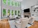 Open living room boasts floor to ceiling windows, fireplace, and a built-in bookcase that creates a cozy atmosphere at 1030 Westbury Dr, Matthews, NC 28104