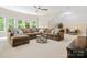 Spacious living room featuring a ceiling fan, large windows, and a comfortable sectional couch at 1030 Westbury Dr, Matthews, NC 28104
