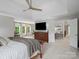 Airy main bedroom features a tray ceiling, TV, windows, and cozy sitting area at 1030 Westbury Dr, Matthews, NC 28104