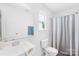 Bright bathroom featuring white fixtures, a decorative window, and a stylish striped shower curtain at 105 Altondale Dr, Statesville, NC 28625