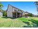 Spacious backyard with lush green grass, a screened-in porch, patio with seating, and professional landscaping at 106 Sweet Briar Dr, Fort Mill, SC 29707