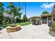 Beautiful backyard features a stone fire pit, paver patio, lush greenery, and a screened-in porch at 106 Sweet Briar Dr, Fort Mill, SC 29707