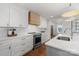 Modern kitchen featuring white cabinets, stainless steel appliances, and wooden vent hood at 1314 Ordermore Ave, Charlotte, NC 28203