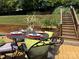 Outdoor dining table set for four on back deck surrounded by lush lawn at 1404 River Dr, Belmont, NC 28012