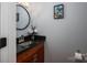 Elegant powder room with a granite countertop, a round mirror, and a decorative flower arrangement at 1404 River Dr, Belmont, NC 28012