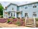 Charming two-story townhome featuring a well-maintained garden with flowering plants and a cozy front porch at 1404 River Dr, Belmont, NC 28012