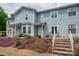 Charming townhome featuring blue siding, well-manicured landscaping, and a welcoming front porch at 1404 River Dr, Belmont, NC 28012
