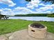 Outdoor entertaining space with a cozy stone fire pit, perfect for enjoying the lake views at 1404 River Dr, Belmont, NC 28012