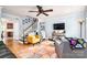 Cozy living room with hardwood floors, a ceiling fan, comfortable seating, and a staircase at 1404 River Dr, Belmont, NC 28012