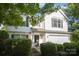 Two-story home features white siding, dark shutters, a two-car garage, and mature landscaping at 14311 Riding Hill Ave, Charlotte, NC 28213