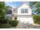 Charming two-story home with a two-car garage, manicured bushes, and dark shutters at 14311 Riding Hill Ave, Charlotte, NC 28213