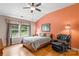 Cozy bedroom with hardwood floors, a large window, and an accent wall in a warm, inviting hue at 1680 Beleek Ridge Ln, Clover, SC 29710
