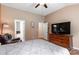 Carpeted bedroom featuring a ceiling fan, mounted television, and attached bathroom at 1680 Beleek Ridge Ln, Clover, SC 29710
