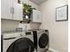Modern laundry room featuring upper cabinets, a clothing rod, and a front-load washer and dryer at 1680 Beleek Ridge Ln, Clover, SC 29710