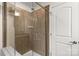 Close-up of stand-up shower, featuring brown tiling, glass door, and a built-in bench at 1680 Beleek Ridge Ln, Clover, SC 29710