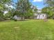 Expansive backyard with a detached garage, storage shed, and play area at 1714 Edgewater Dr, Charlotte, NC 28210