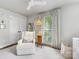Cozy bedroom featuring a comfortable armchair, hardwood floors, and large windows at 1714 Edgewater Dr, Charlotte, NC 28210