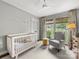 Charming bedroom featuring a cozy crib, natural light, and classic design elements at 1714 Edgewater Dr, Charlotte, NC 28210