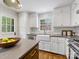 Kitchen showcasing stainless steel appliances, white cabinetry, subway tile backsplash and farm sink at 1714 Edgewater Dr, Charlotte, NC 28210