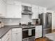 Bright kitchen features stainless steel appliances, white cabinetry, subway tile backsplash, and modern fixtures at 1714 Edgewater Dr, Charlotte, NC 28210