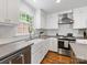 Charming kitchen with hardwood floors, white cabinetry, stainless-steel appliances, and a farmhouse sink at 1714 Edgewater Dr, Charlotte, NC 28210