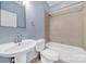Clean bathroom featuring a toilet, sink, and a shower/tub combo with tan tiling and blue walls at 2200 Lyndhurst Ave # 203, Charlotte, NC 28203