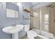 Modern bathroom featuring a sleek sink, toilet, shelves, and tiled shower with glass door at 2200 Lyndhurst Ave # 203, Charlotte, NC 28203