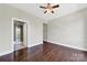 Open bedroom layout featuring hardwood floors, a ceiling fan, and a bathroom entrance at 2200 Lyndhurst Ave # 203, Charlotte, NC 28203