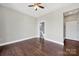 An empty bedroom featuring laminate flooring, a ceiling fan, and a bathroom entrance at 2200 Lyndhurst Ave # 203, Charlotte, NC 28203