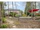 Beautiful backyard with lovely landscaping, a red umbrella, seating, and mature trees at 2620 Shady Reach Ln, Charlotte, NC 28214