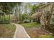 Landscaped backyard featuring a stone path, a covered patio, and mature trees for a private outdoor space at 2620 Shady Reach Ln, Charlotte, NC 28214