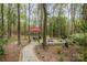 Scenic backyard featuring mature trees, a fire pit, an umbrella, and a quaint brick path at 2620 Shady Reach Ln, Charlotte, NC 28214