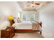 Comfortable bedroom with a tray ceiling, ceiling fan, and ample natural light, providing a relaxing and airy atmosphere at 2620 Shady Reach Ln, Charlotte, NC 28214